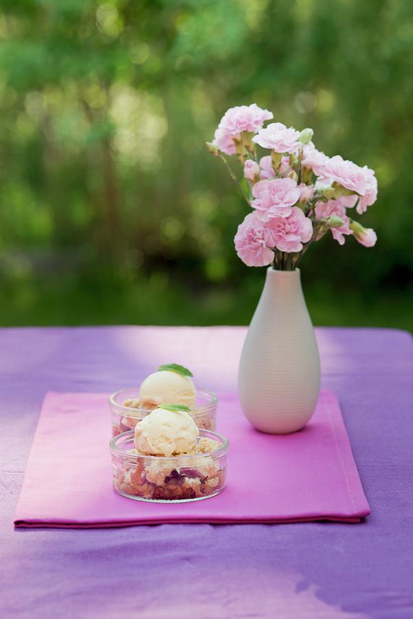 Strawberry Crumble With Vanilla Ice Cream In Dessert Dishes On A Garden Table Photograph by Ewa Rejmer