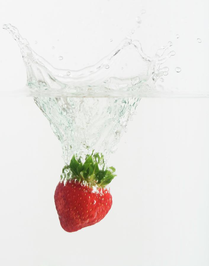 Strawberry Dropped Into Water Photograph by Tetra Images