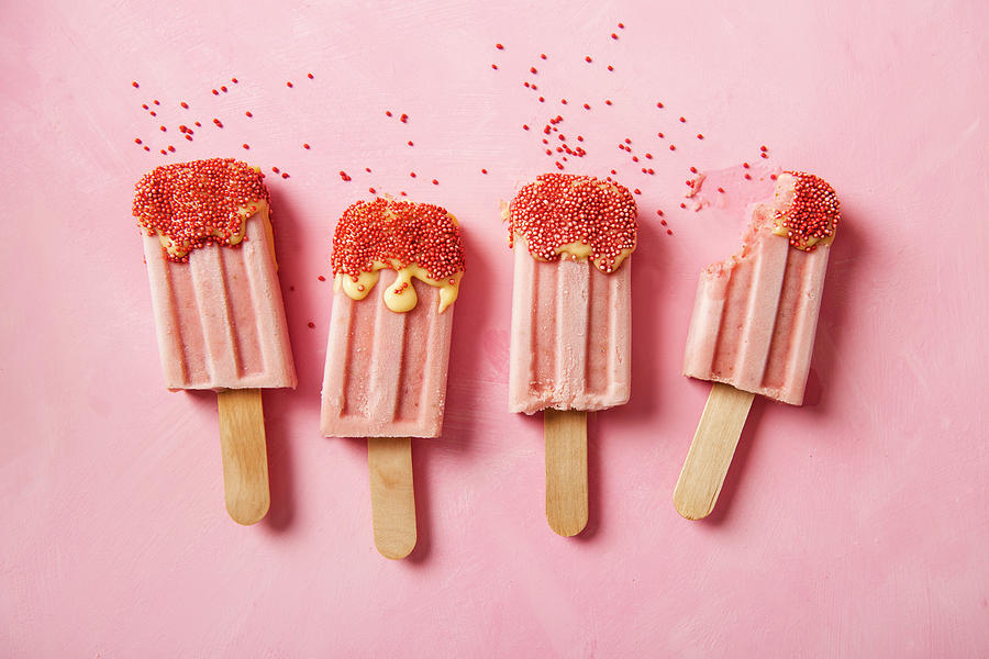 Strawberry Ice Cream Lollies With Sugar Sprinkles, One With A Bite Taken Out Photograph by Magdalena Hendey