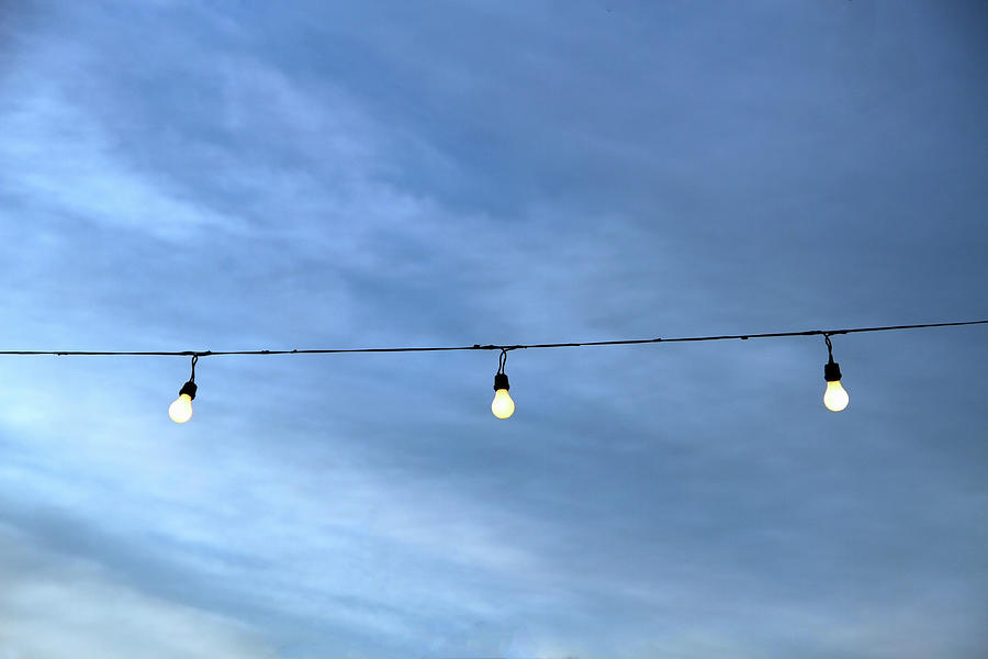 String Of Lightbulbs Against A Cloudy Photograph by 2ndlookgraphics