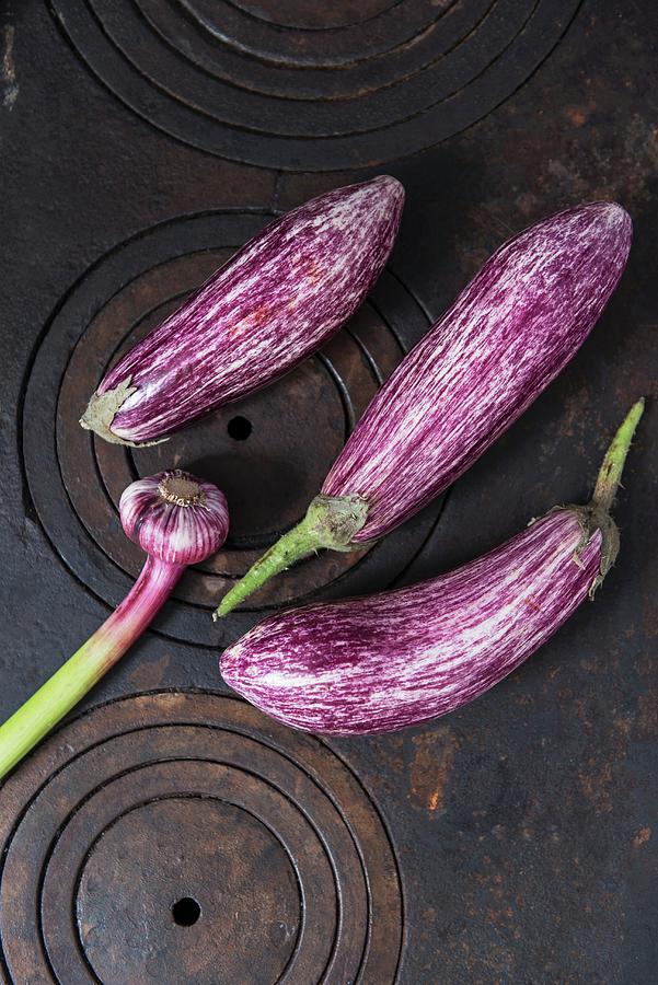 Striped Aubergines And Fresh Garlic On A Cast-iron Stove Photograph by Angelika Grossmann