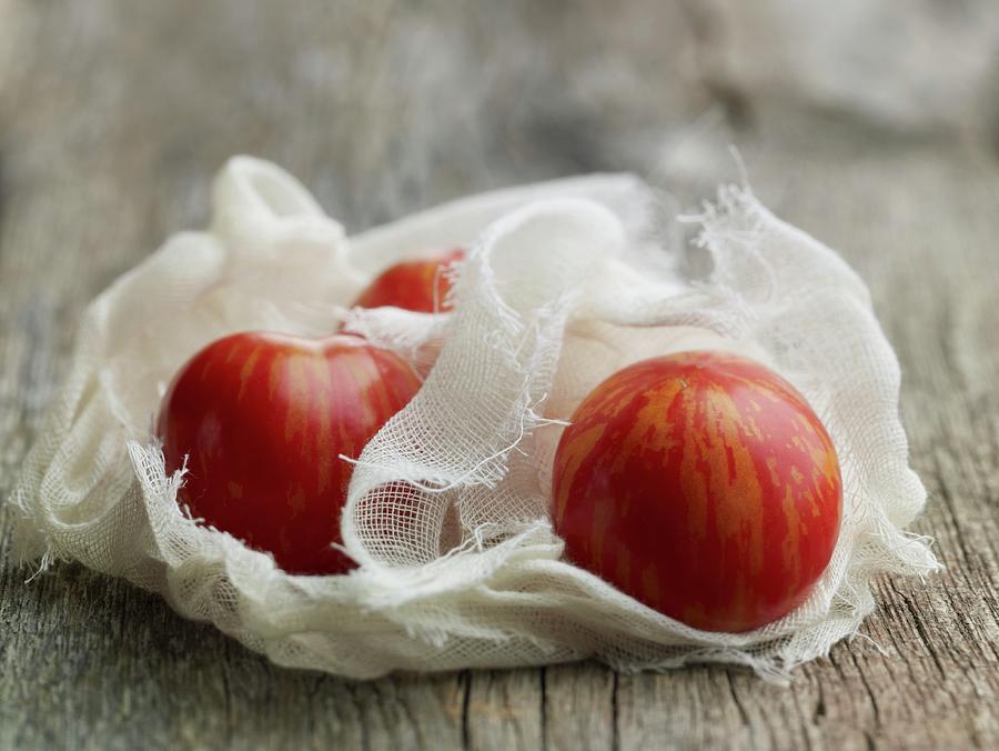 Stripped Organic Tomatoes In A Muslin Cloth Photograph by Rene Comet