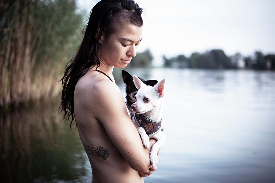 Nature Photograph - Strong Asian Woman Holds Two Small Dogs In Natural Berlin Lake by Cavan Images