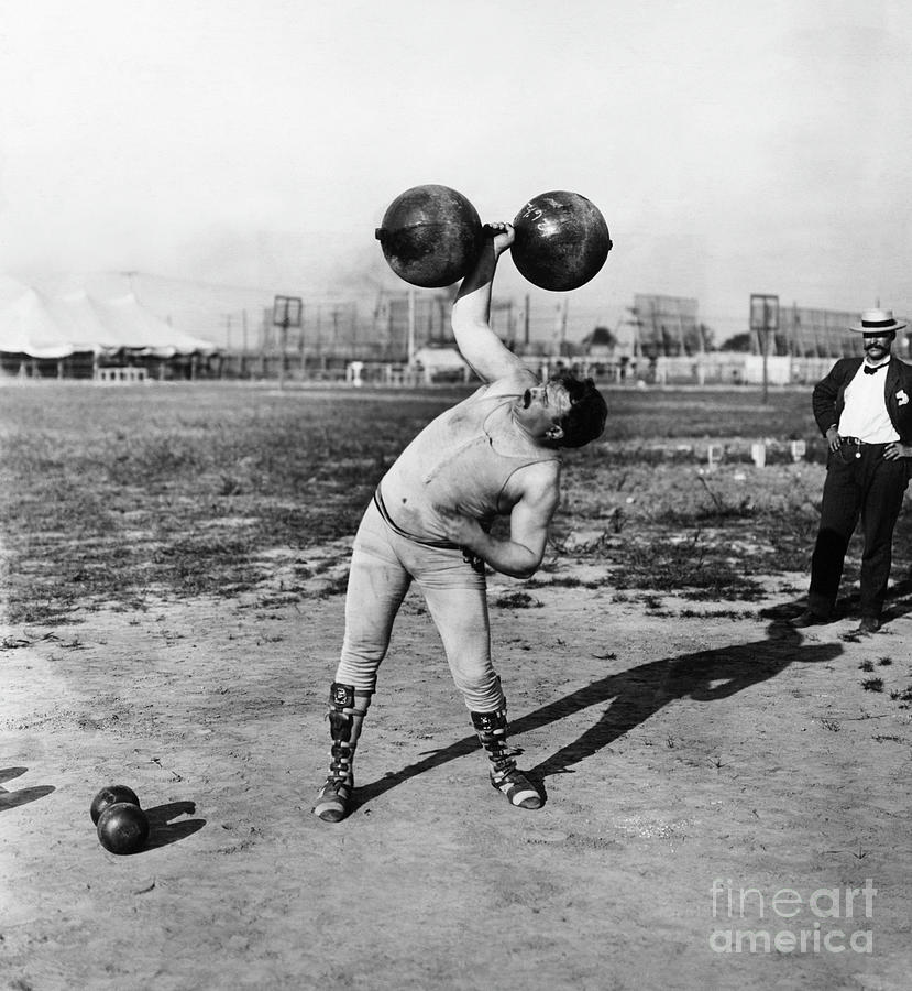 Strongman Lifting Dumbell Photograph by Bettmann