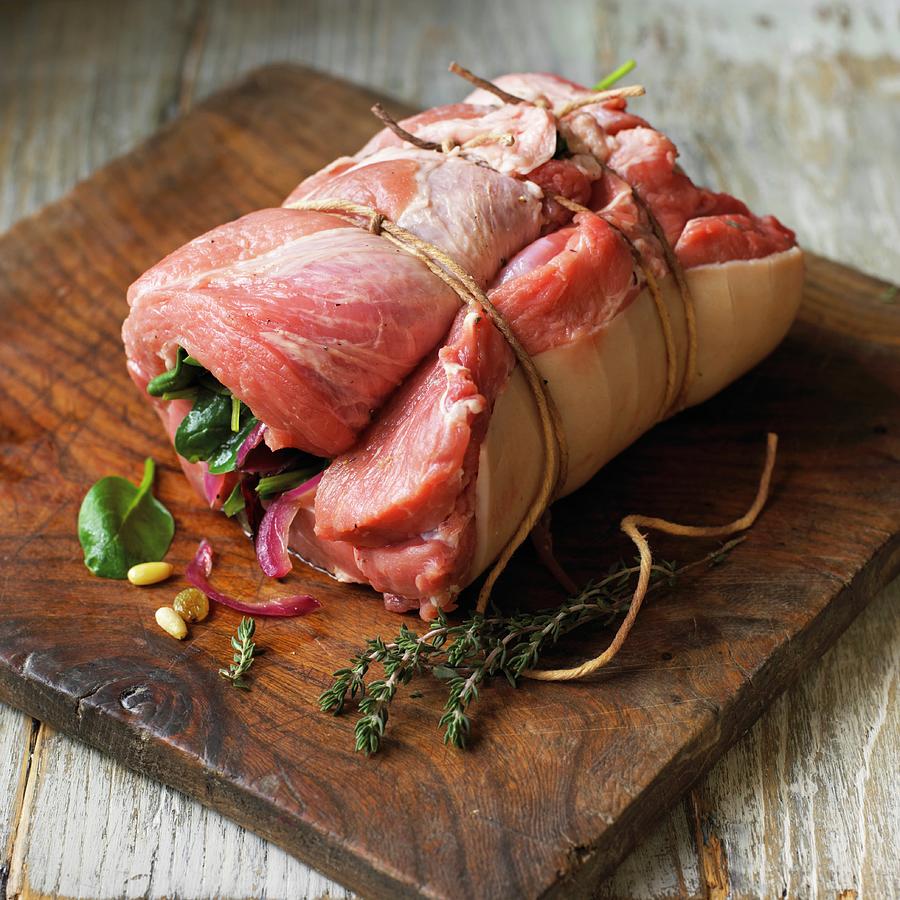 Stuffed, Rolled Pork Shoulder On A Chopping Board Photograph by Reavell, William