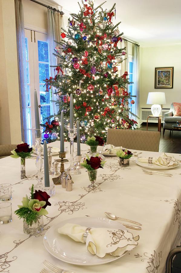 Subtly Patterned Table Cloth, Napkins And Roses On Festive Table With Christmas Tree In Background Photograph by Anastassios Mentis Photography