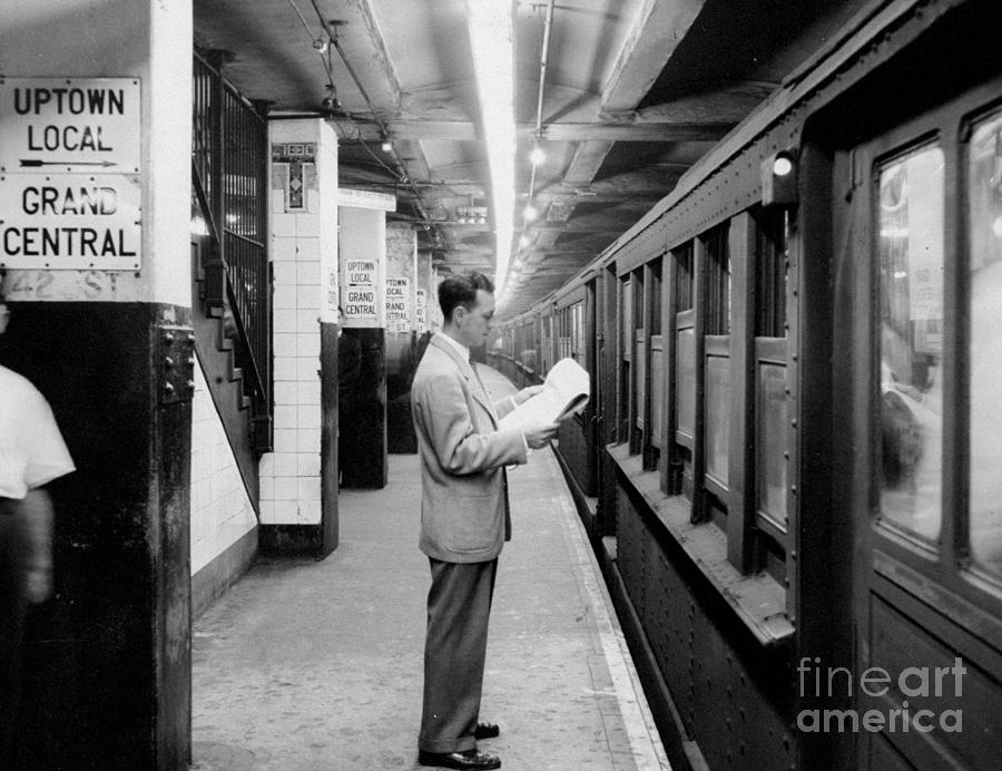 Subway Passenger Reads His Paper Under Photograph by New York Daily News Archive