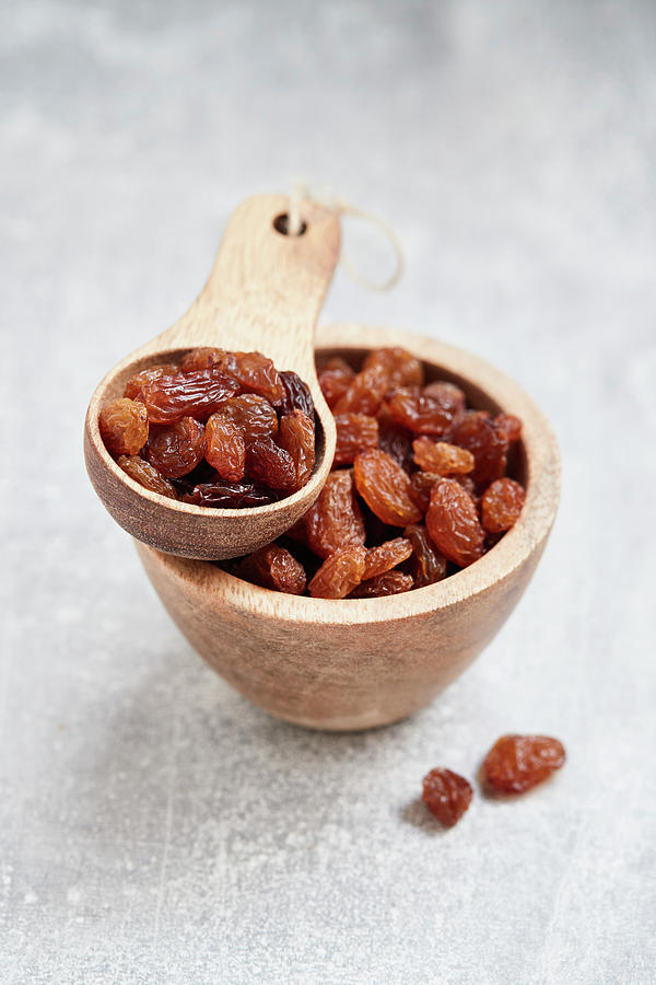 Sultanas In A Wooden Bowl And A Wooden Scoop Photograph by Brigitte Sporrer