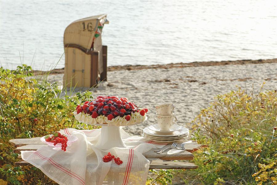 Summer Berry Cake On A Wooden Bench On The Beach Photograph by Ursula Sonnenberg