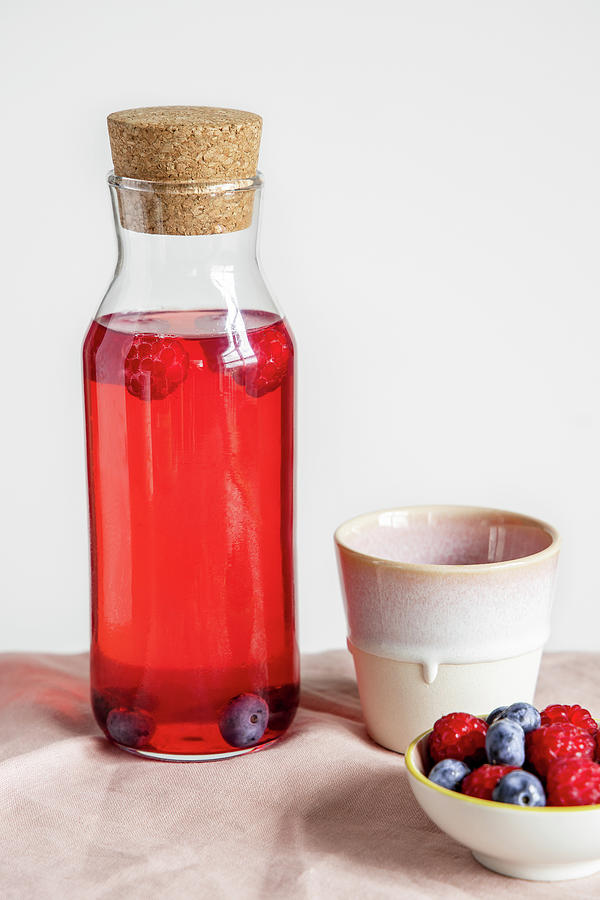 Summer Drink With Berries In A Glass Bottle Photograph by Alla Machutt