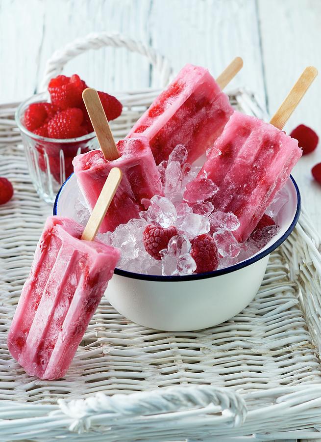 Summer Raspberry Ice Lollies On Sticks With Fresh Raspberries On Crushed Ice Photograph by Stefan Schulte-ladbeck