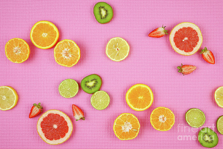 Summer theme background with fruit, citrus and flowers on pink backdrop. Photograph by Milleflore Images