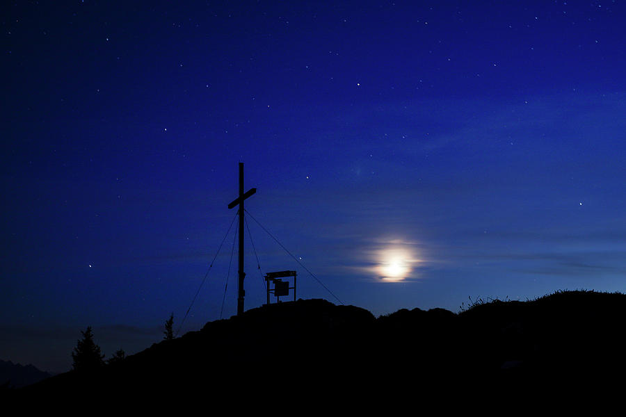 Summit Cross Of The Jochberg At Night With Clouds, Stars And Moon Photograph by Bastian Linder