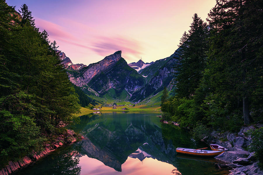 Sunset over the Seealpsee lake with small boats in the Swiss Alps ...