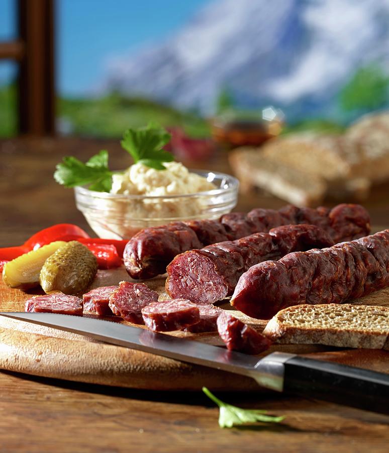 Supper With Kaminwurzen south Tyrolean Smoked Sausages, Horseradish And Vinschgau Bread Against A Mountain Backdrop Photograph by Ludger Rose