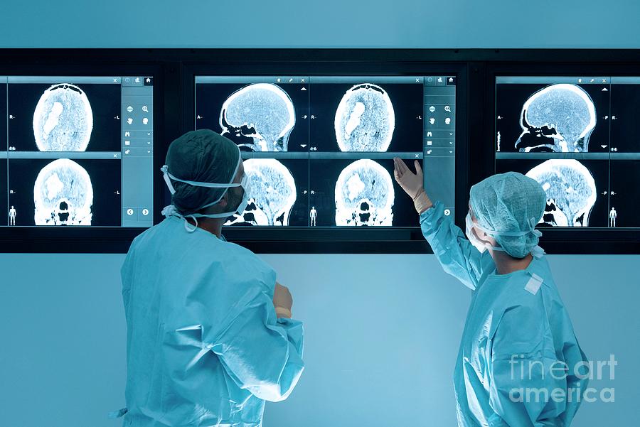 Surgeons Looking At Mri Scans During Surgery Photograph by Science Photo Library