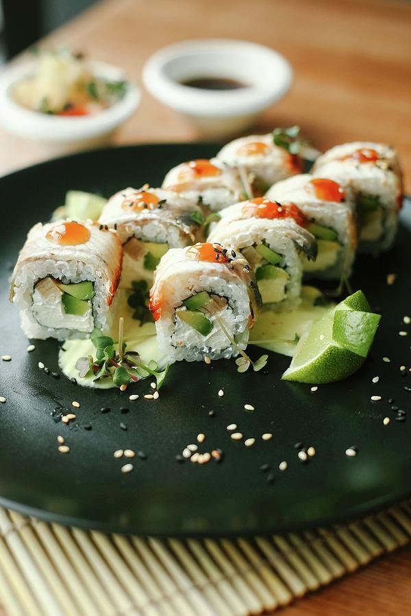 Sushi With Fish, Avocado And Fresh Cheese On A Black Plate Photograph by Kuzmin5d