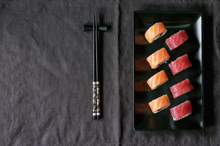 Sushi With Salmon And Tuna Fish On A Black Plate Next To Chopsticks japan Photograph by Natasha Breen