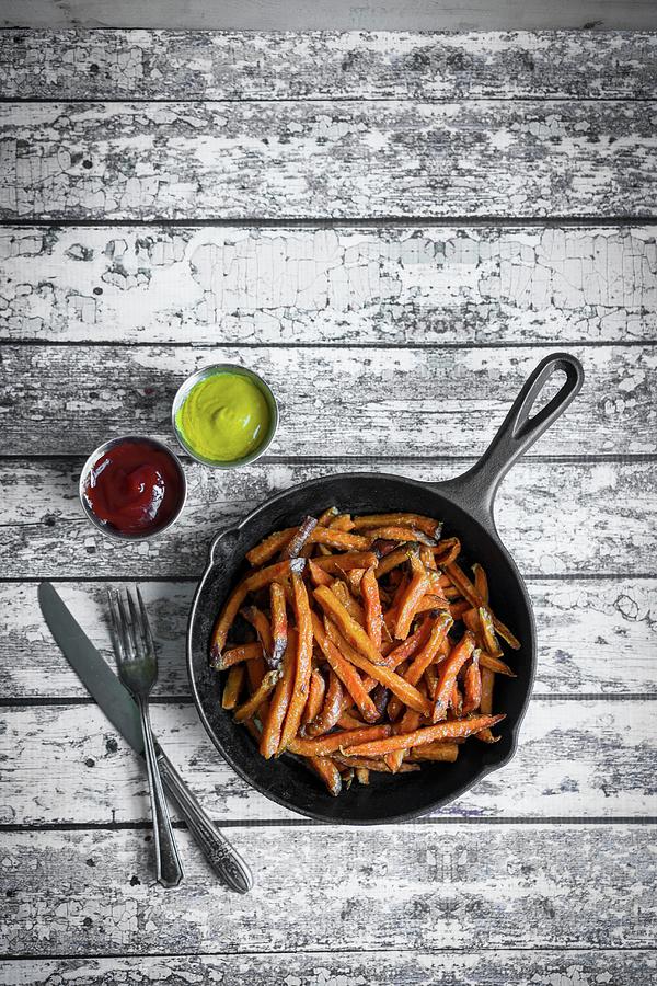 Sweet Potato Fries In Cast Iron Pan On A Rustic Wooden Surface Photograph by Alena Haurylik