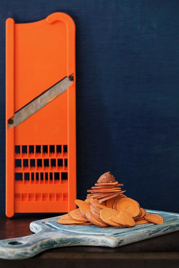 Sweet Potato Slices On A Chopping Board With A Slicer Photograph by Yelena Strokin