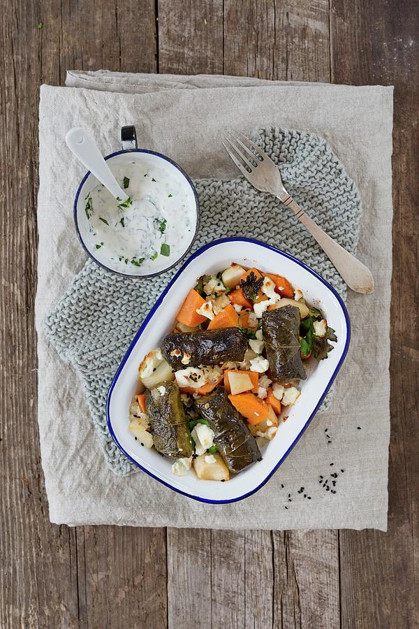 Sweet Potatoes With Stuffed Vine Leaves And Sheeps Cheese In A Baking Dish, And A Herb Yoghurt Dip Photograph by Tina Engel