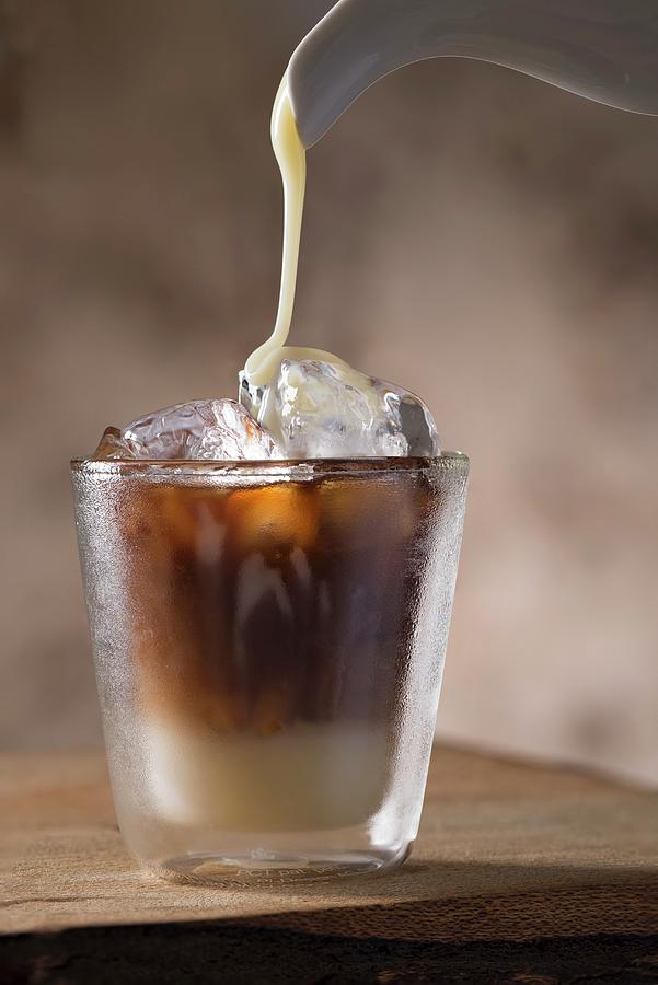 Sweetened Condensed Milkbeing Poured Into A Glass Of Vietnamese Iced Coffee Photograph by Laurange