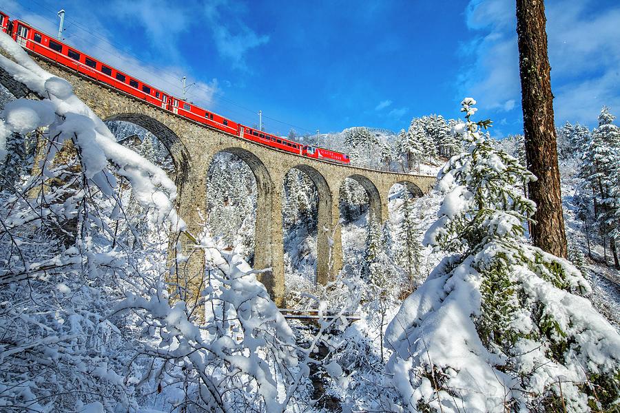 Switzerland, Grisons, Alps, Bernina Express Passes Through The Snowy Woods Filisur Digital Art by Roberto Moiola