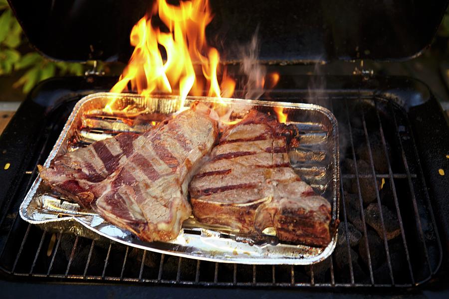 T-bone Steaks In An Aluminium Tray On A Barbecue Photograph by Jo Kirchherr