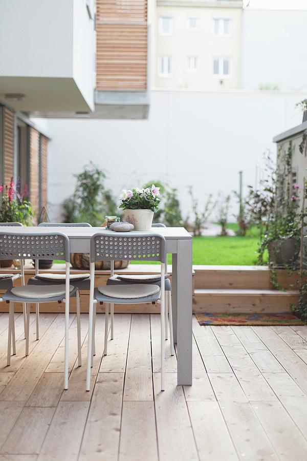 Table And Chairs On Wooden Deck In Courtyard Photograph by Wiener Wohnsinn