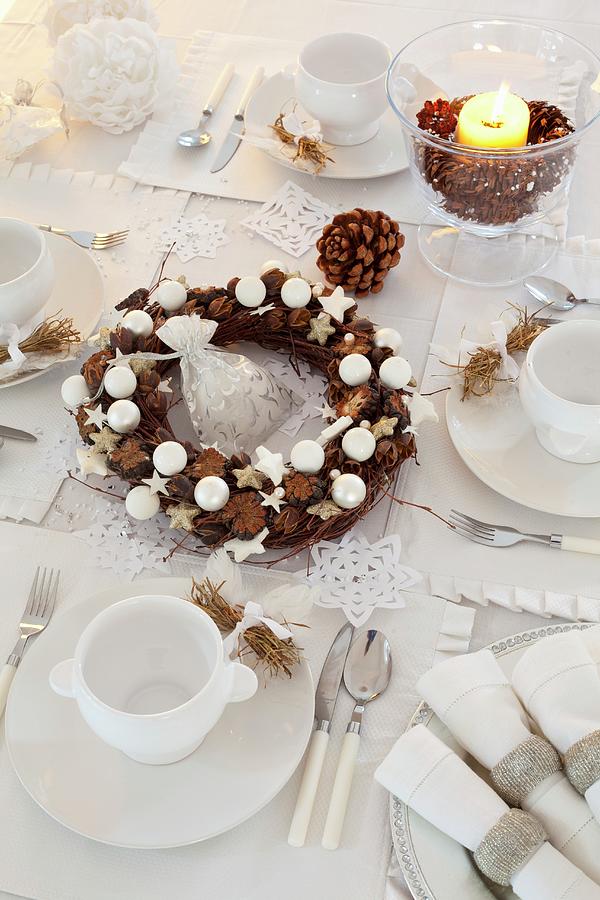 Table Festively Set In White With Wreath Of Pine Cone And Baubles Photograph by Studio Lipov
