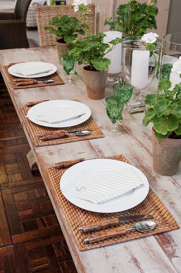 Table Set With Green Crystal Glasses, Woven Place Mats And Geraniums In Terracotta Pots Photograph by Great Stock!