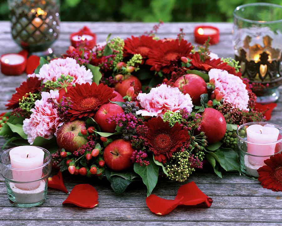 Table Wreath Of Gerbera, Carnations And Apples Photograph by Friedrich Strauss