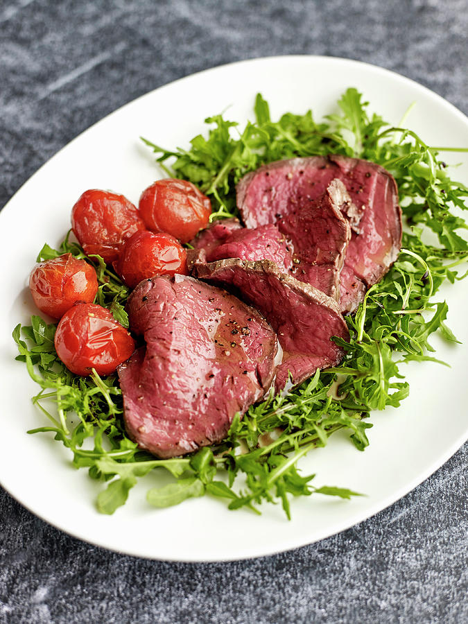 Tagliata Di Manzo beef Fillet On A Bed Of Rocket With Cocktail Tomatoes, Italy Photograph by Herbert Lehmann