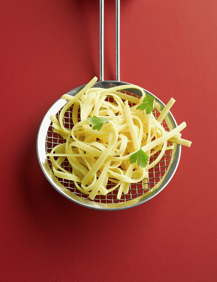 Tagliatelle In Colander On Red Photograph by Westend61
