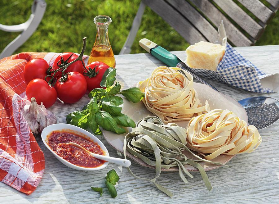 Tagliatelle, Tomato Sauce And Ingredients On A Garden Table Photograph by Peter Garten