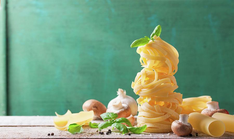 Tagliatelle With Mushrooms, Basil, Garlic And Pepper On A Wooden Board Photograph by Valeria Aksakova