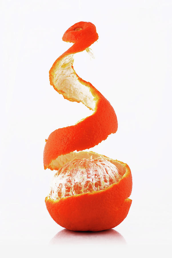 Tangerine Being Pealed Over A White Photograph by Chang