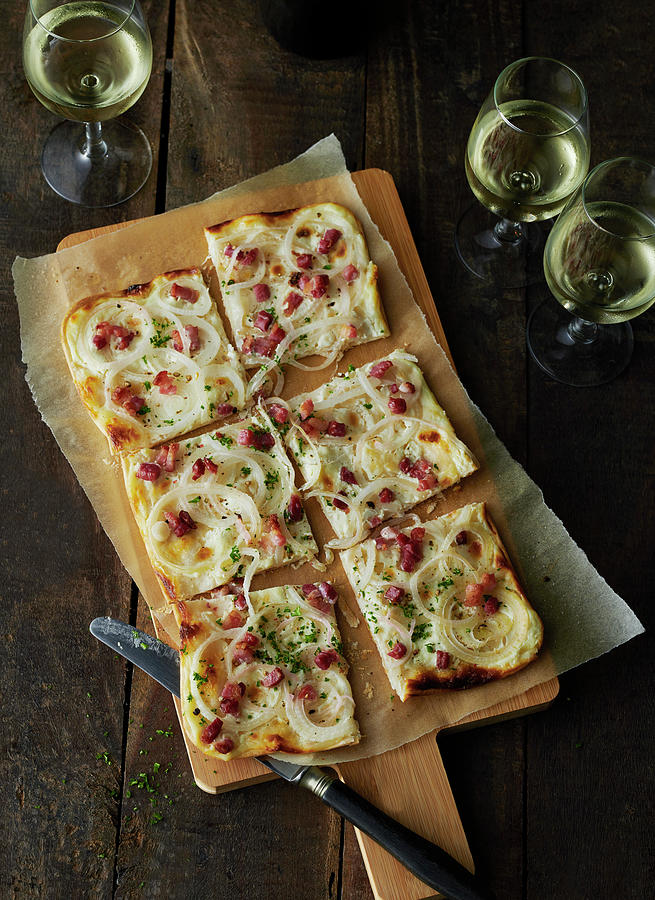 Tarte Flambe With Bacon And Onions On A Wooden Board With Three Glasses Of Wine Photograph by Stefan Schulte-ladbeck