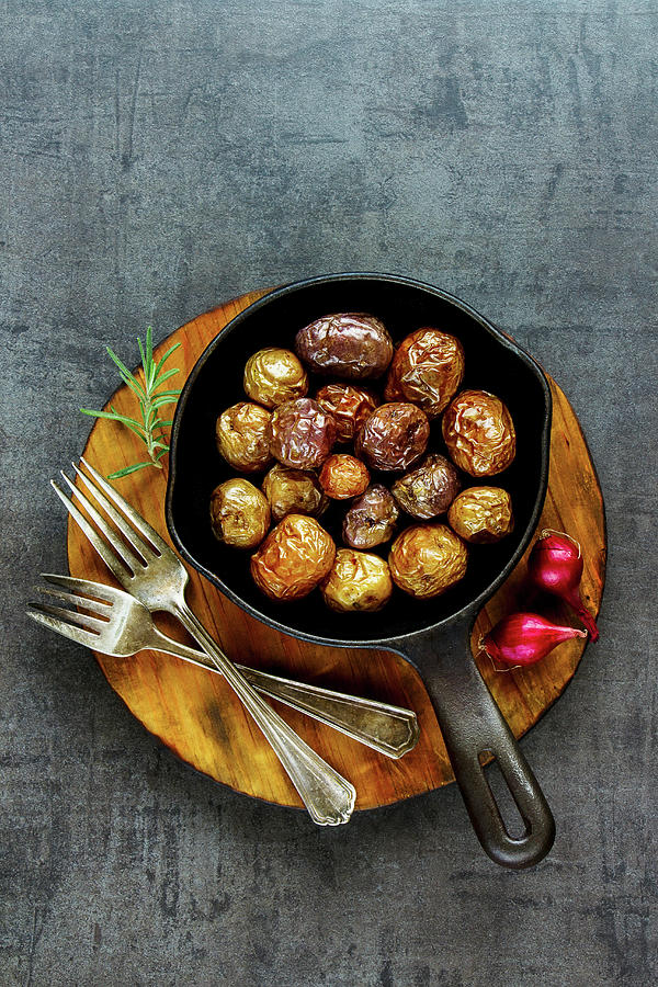 Tasty Fried Baby Potatoes In Vintage Cast Iron Pan On Wooden Board Over Black Concrete Background Photograph by Yuliya Gontar