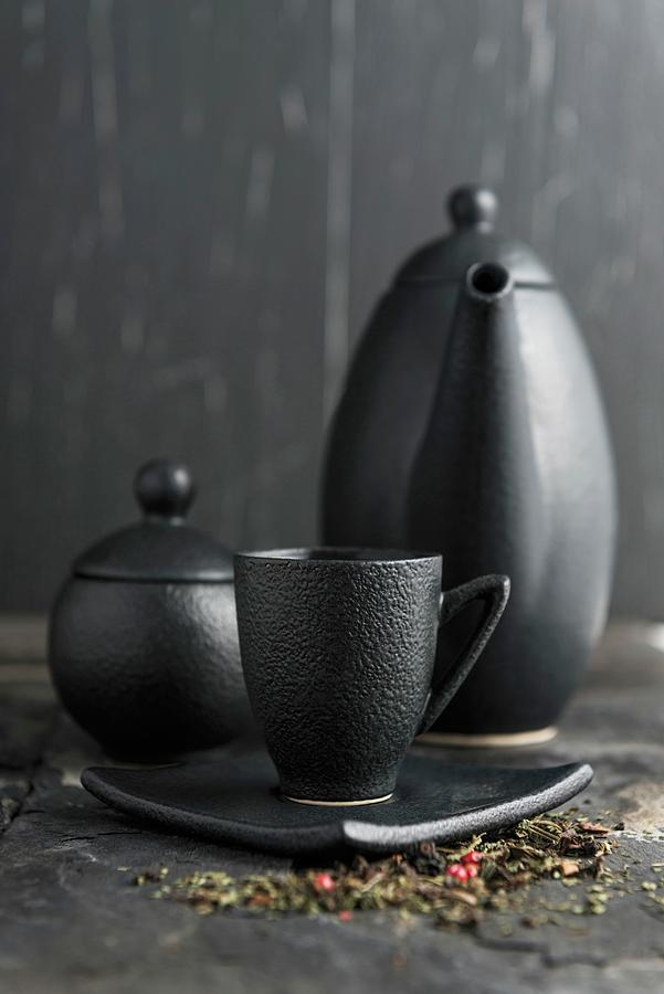 Tea In A Black Cup In Front Of A Teapot And Sugar Pot Photograph by Komar