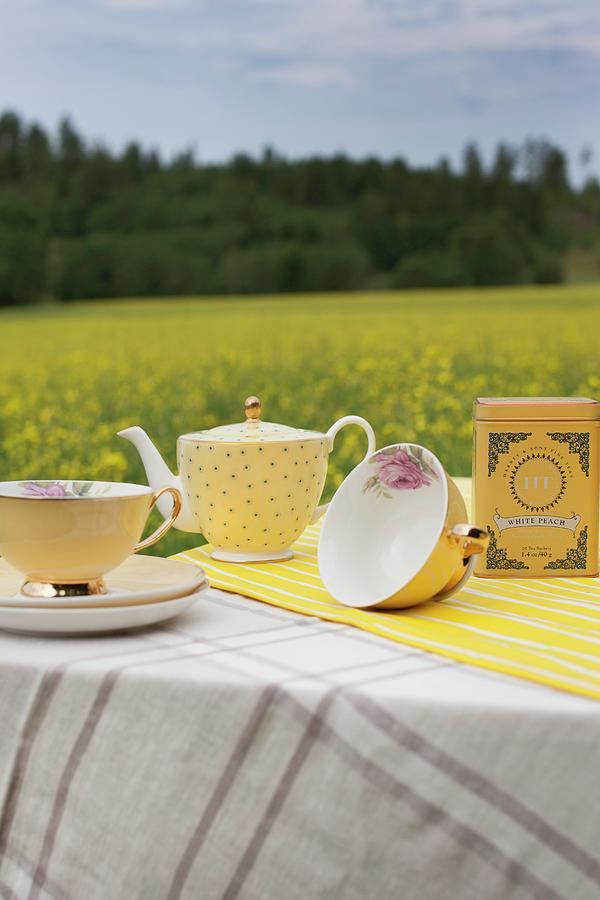 Teacups And Polka-dot Teapot On Table Outdoors Photograph by Annette Nordstrom