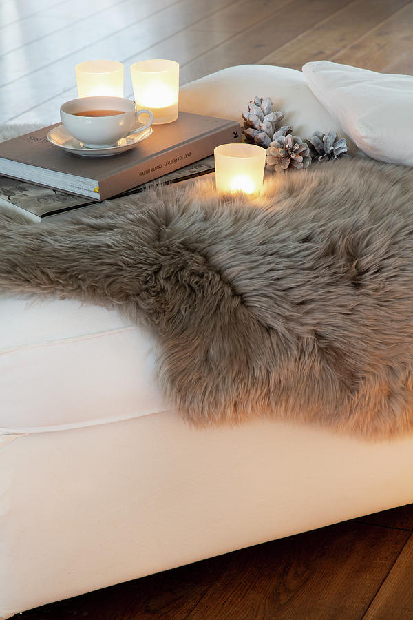 Tealights, Books And Cup Of Tea On Fur Blanket Photograph by Catja Vedder