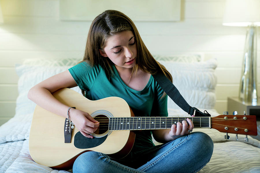 Teenage Girl Plucking Guitar In Bedroom Photograph by Cavan Images ...