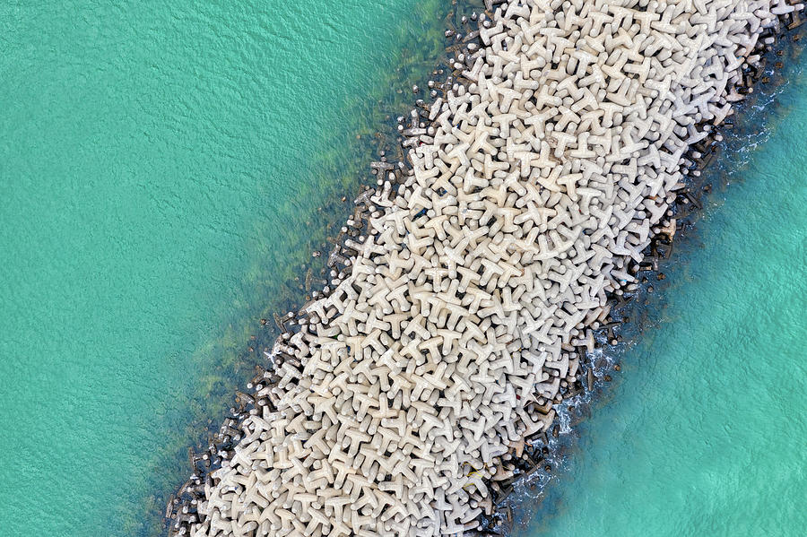 Tetrapod Breakwater in turquoise water, taken in Kuwait in Decem Photograph by Lukas Bischoff