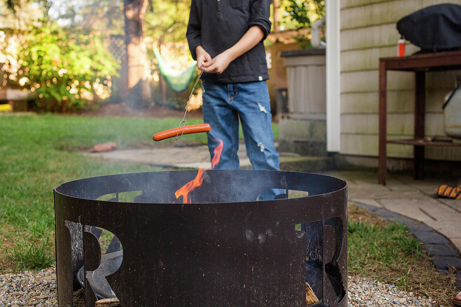 Fall Photograph - The Bottom Half Of A Boy Roasting Hot Dog Over Outdoor Fire Pit by Cavan Images
