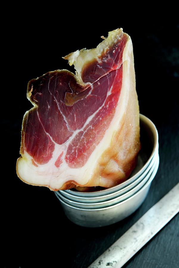 The End Of A Whole Of Prosciutto Next To A Ham Knife Photograph by Jamie Watson