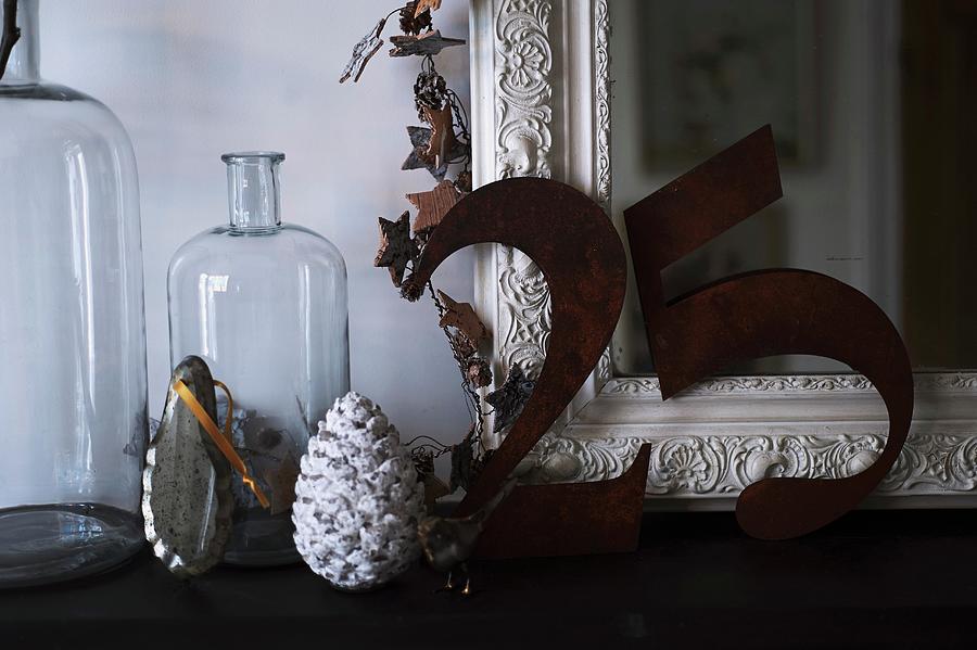 The Number 25 In Metal Digits Leaning On Antique Mirror Next To Glass Demijohn Bottles And Christmas Decorations Photograph by Andrew Boyd
