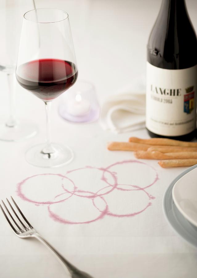 Wine Photograph - The Olympic Rings Marked In Red Wine On A White Tablecloth by Imagerie