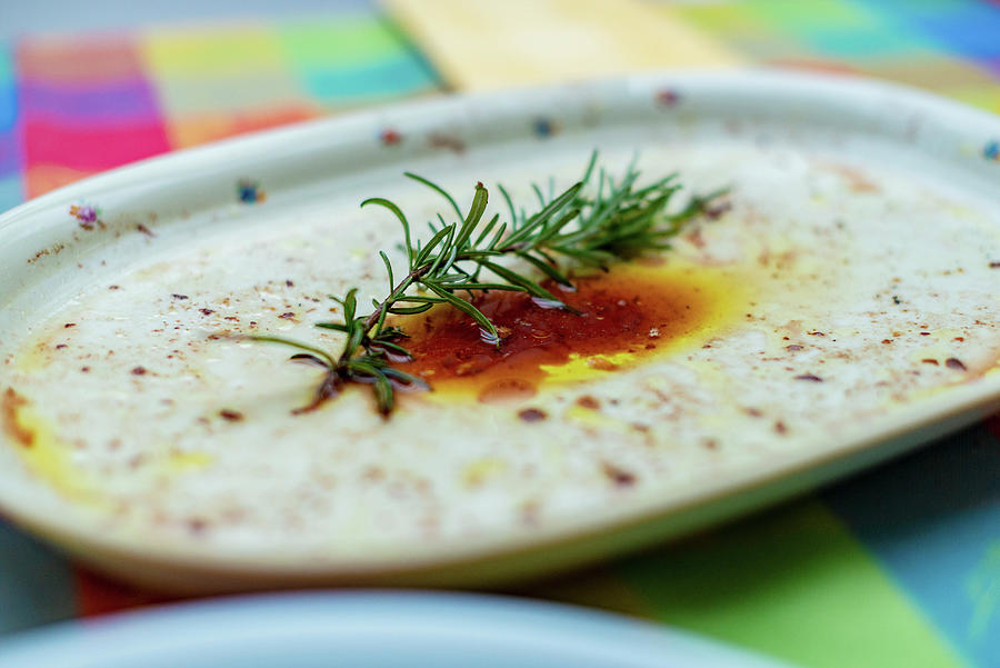 The Remains Of A Marinade And Rosemary On A Serving Platter Photograph by Sebastian Schollmeyer