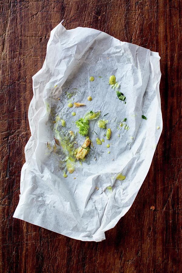 The Remains Of A Salmon Burger On A Piece Of Parchment Paper Photograph by Claudia Timmann